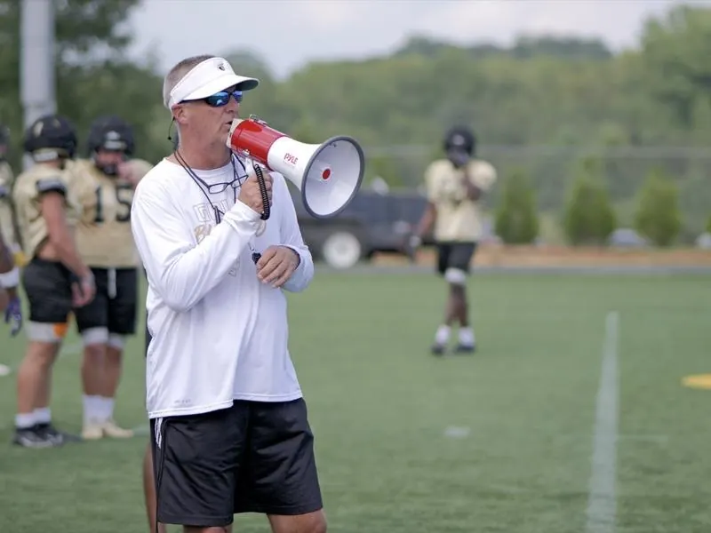 An Anderson coach on the bullhorn at practice, from Leading the Charge