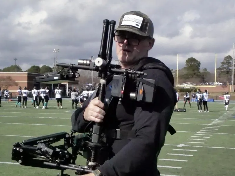 Jason Kendall on the field with a Steadicam rig, filming for High School Blitz